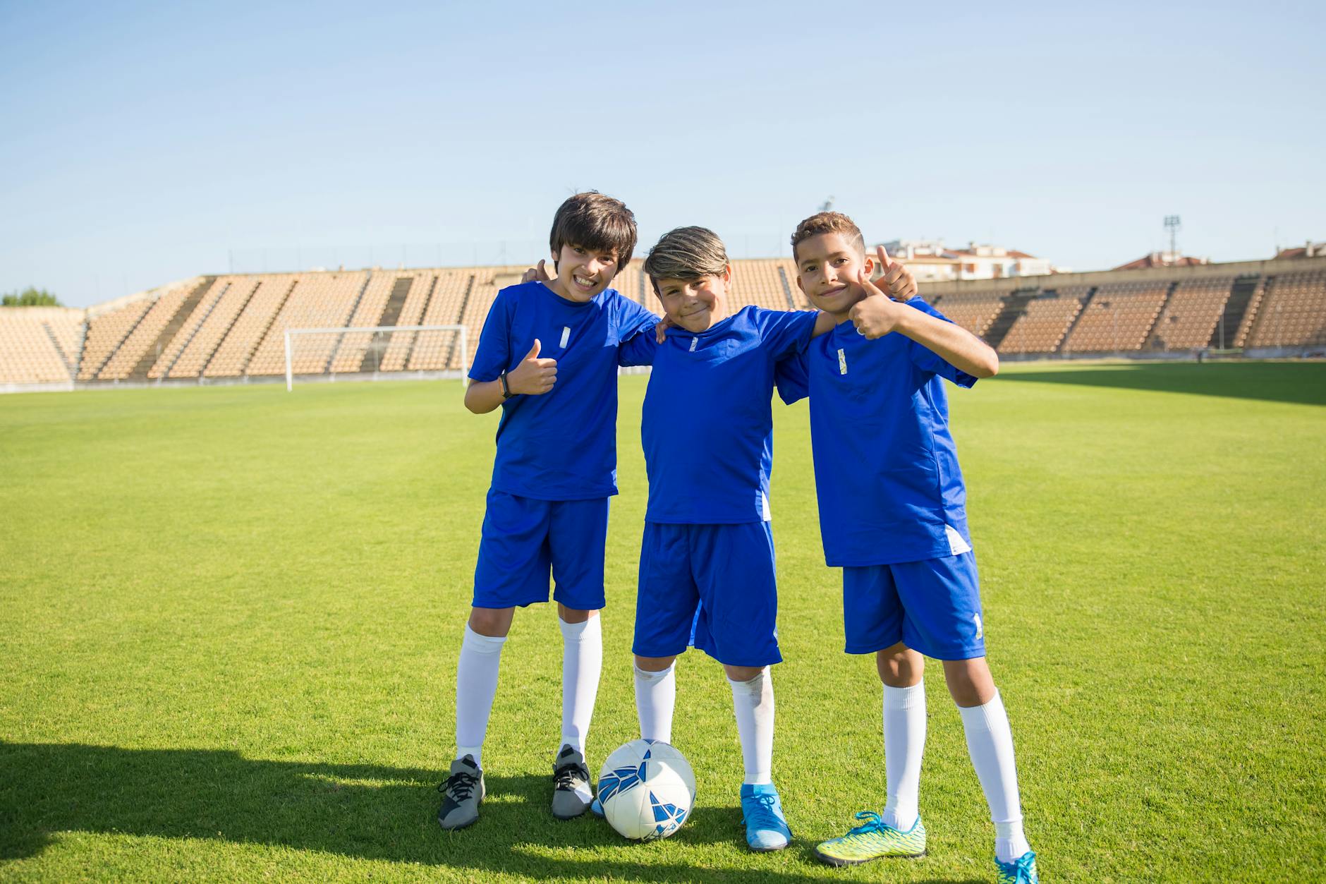 boys in their uniform standing in the soccer field